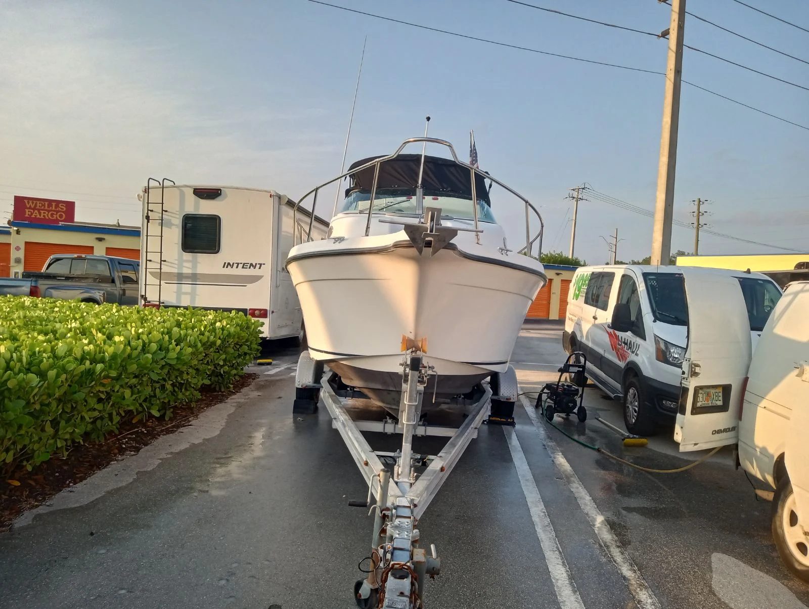 White centre-console boat on a trailer, hull and deck washed down and still wet after a mobile marine detail